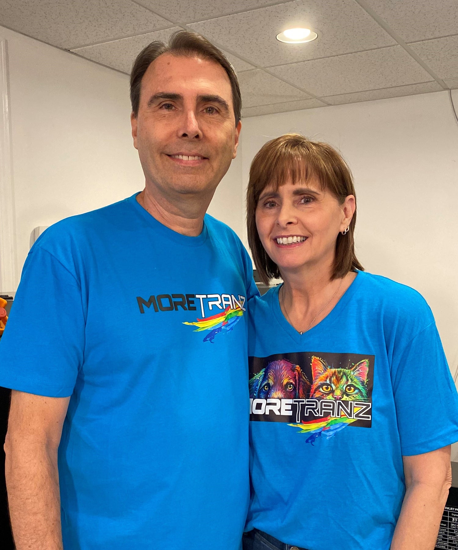 Steve and Jené Morché, founders of MoreTranz, wearing DTF-printed shirts at their Lawrenceville, Georgia print shop